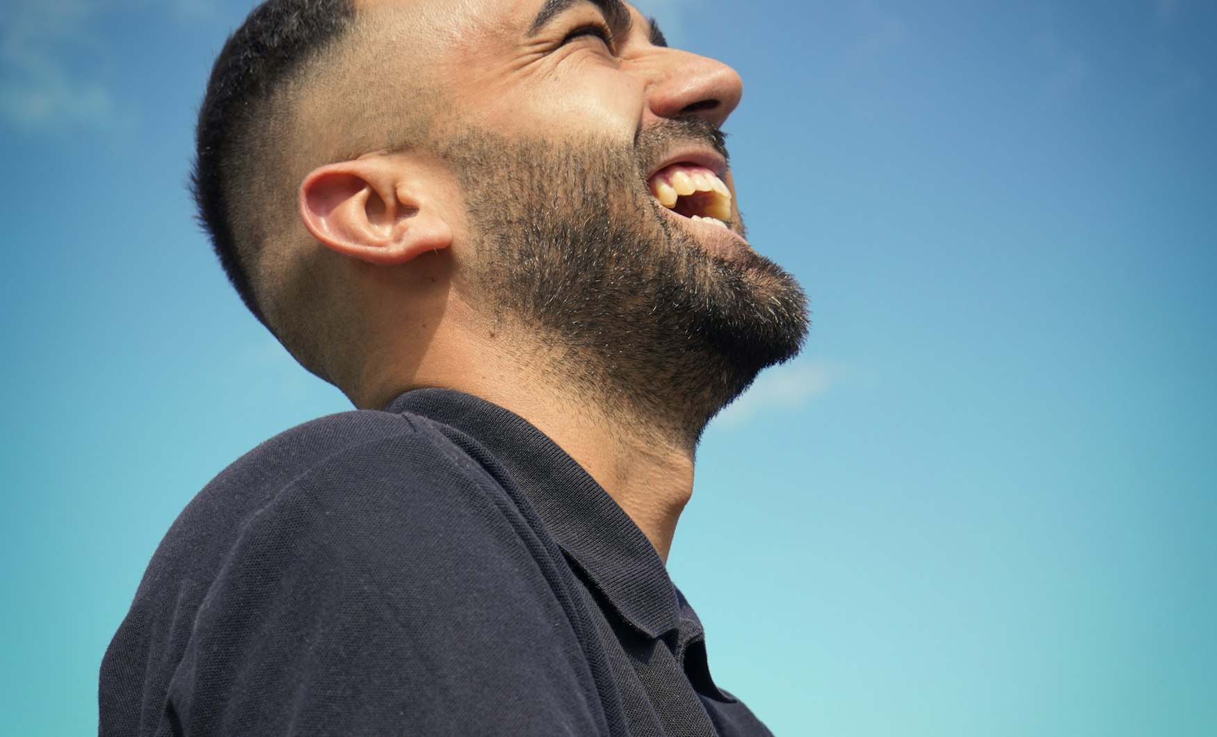 A man laughing, head tilted back