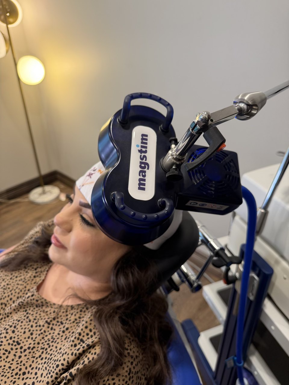 A patient resting under the Magstim coil during a TMS session