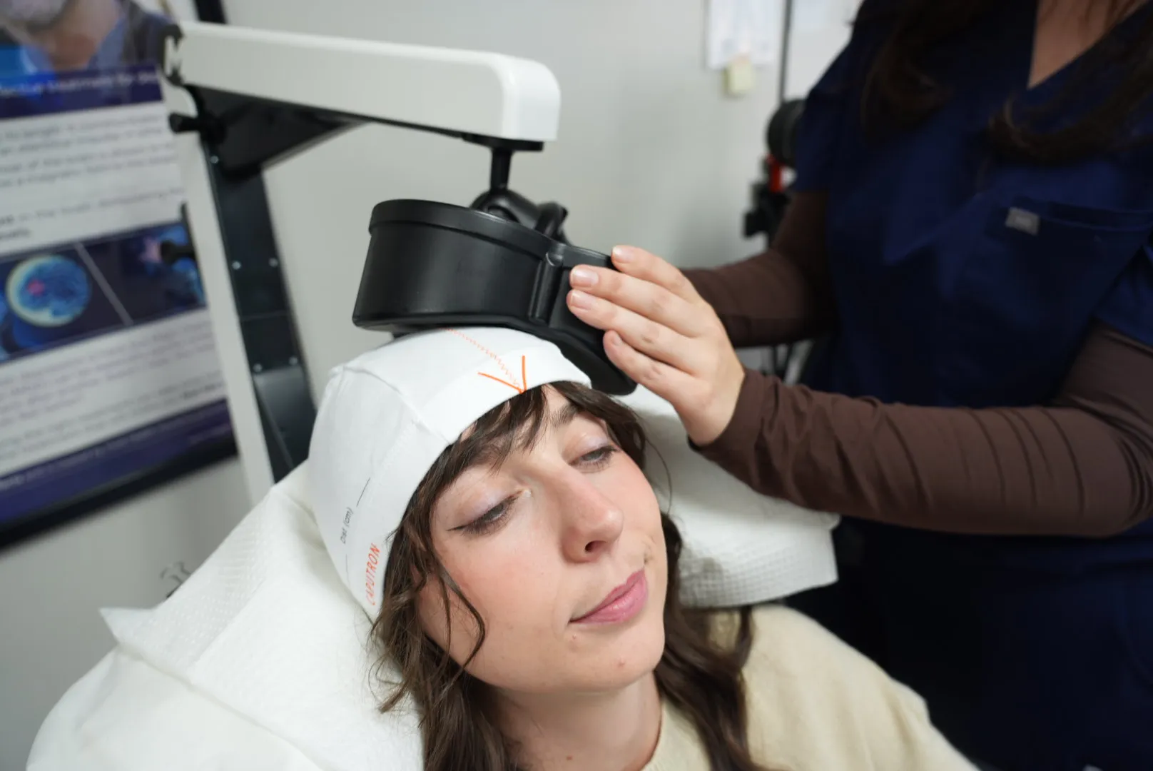 A clinician positioning the TMS coil over a patient’s head